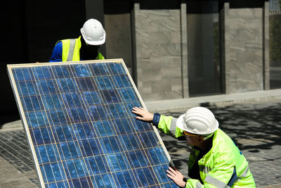 Engineers installing solar panel outdoors