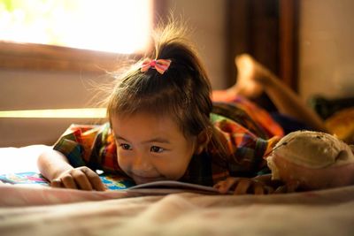 Close-up portrait of girl lying on bed