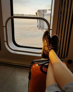 Low section of woman sitting in train