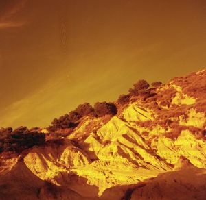 Scenic view of volcanic landscape against sky during sunset