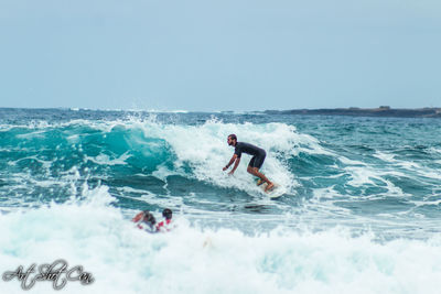 Man surfing in sea against clear sky