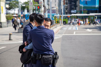 Rear view of people on street in city