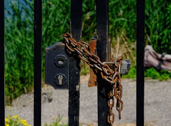 Close-up of rusty chain hanging on metal gate