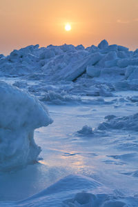 Scenic view of snow covered landscape against sky during sunset