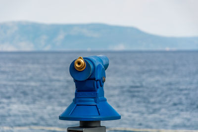 Blue telescope or panoramic binoculars for tourists with sea view