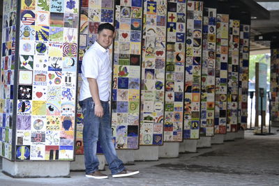 Full length of man standing against multi colored wall