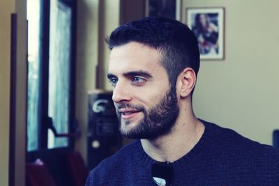 Close-up of thoughtful young man smiling