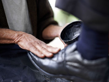 Low section of man tying shoelace