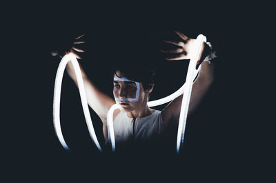 Woman with light painting against black background