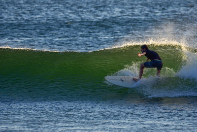 Rear view of man surfing in sea