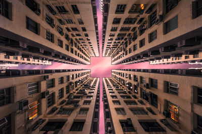 Directly below shot of buildings in city against sky during dusk