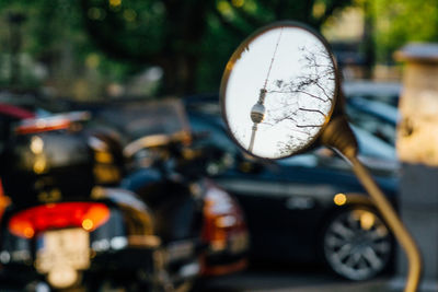 Close-up of fernsehturm reflection in side-view mirror