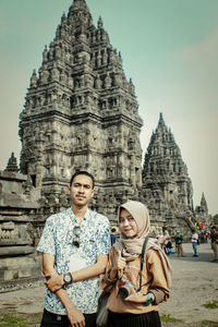 Portrait of couple standing against temple