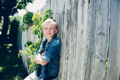 Portrait of sboy leaning against fence