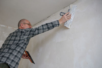 Portrait of man standing against wall