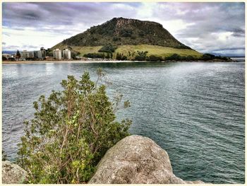 Scenic view of river and mountains against cloudy sky