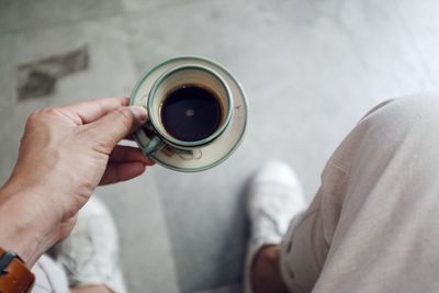 Midsection of man holding coffee cup