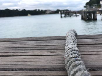 Close-up of pier on lake against sky