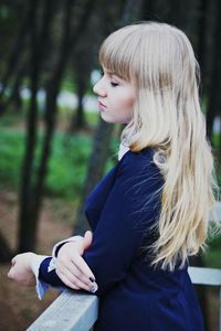 Close-up of woman leaning against railing