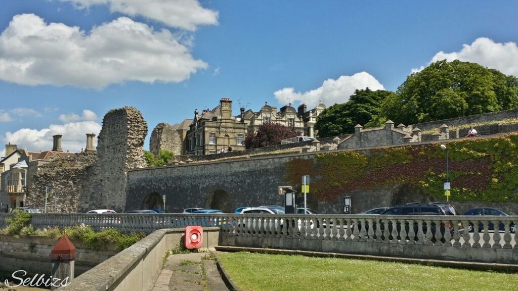 architecture, built structure, sky, building exterior, cloud - sky, cloud, grass, railing, mountain, cloudy, tree, day, incidental people, city, travel destinations, outdoors, green color, travel, nature