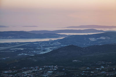 Top view of small city and islands layered with mist after sunset in beautiful tender colors