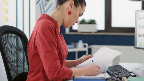 Side view of businesswoman working at desk in office
