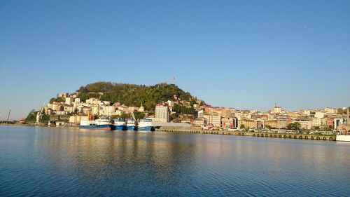 Town by sea against clear sky