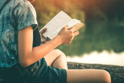 Midsection of woman reading book