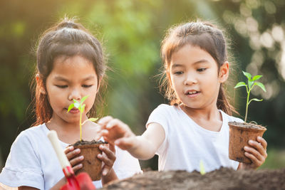 Close-up of girl holding plant in hand outdoors