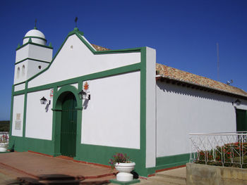 Low angle view of white building against clear blue sky