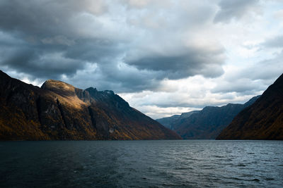 Scenic view of lake by mountains against sky