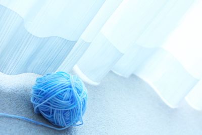 Blue ball of wool by curtain