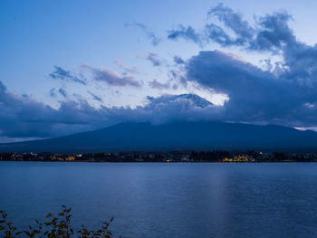 Scenic view of lake and mountains against blue sky