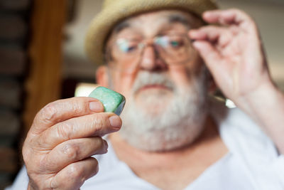 Close-up of senior man holding stone