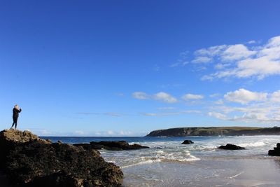 View of calm beach against blue sky