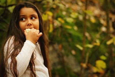 Cute girl eating food during autumn