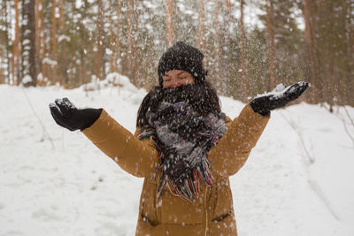 Woman standing on snow covered landscape during winter