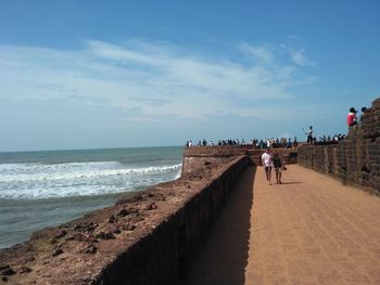 People on beach against sky