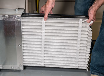 Midsection of man holding air filter