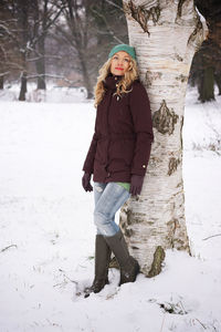 Portrait of woman leaning on tree