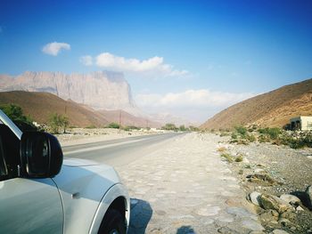 Road by mountain against sky