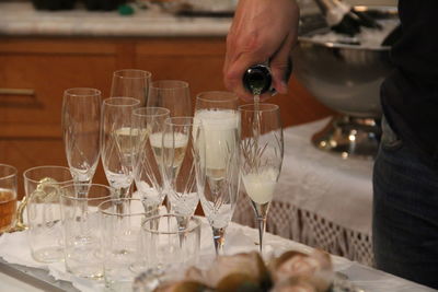 Close-up of hand holding wine glasses on table