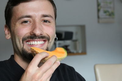 Portrait of a smiling young man holding fruit