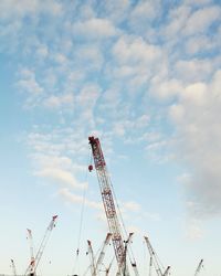 Low angle view of cranes against sky