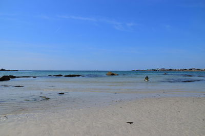 Scenic view of beach against blue sky