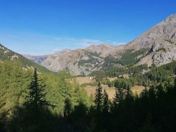 Scenic view of mountains against blue sky