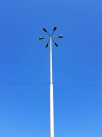 Low angle view of windmill against clear blue sky