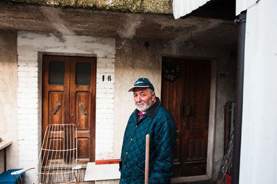 Portrait of smiling man standing against building