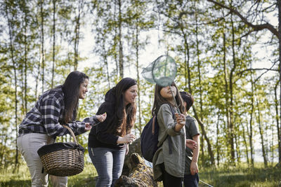 Young women standing by plants in forest