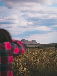 Woman photographing on field against sky